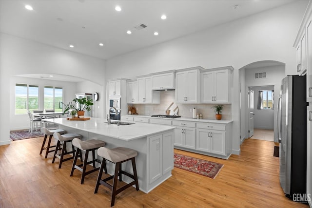 kitchen with white cabinets, sink, a kitchen island with sink, and appliances with stainless steel finishes