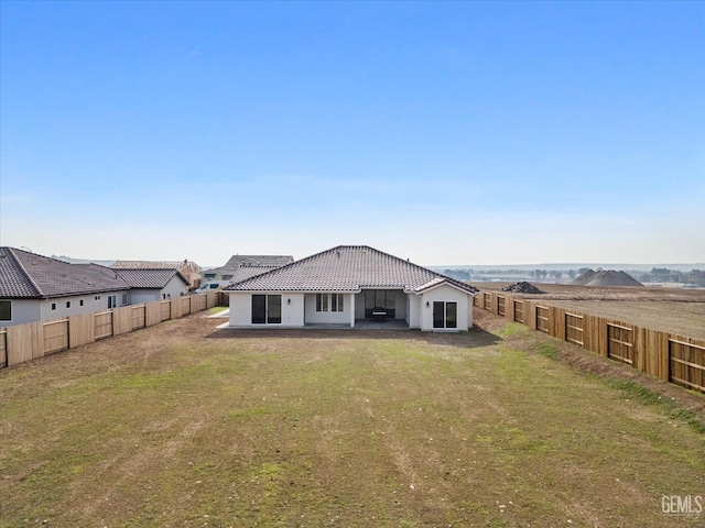 rear view of house with a mountain view, a yard, and a patio