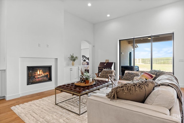 living room featuring hardwood / wood-style flooring and a towering ceiling