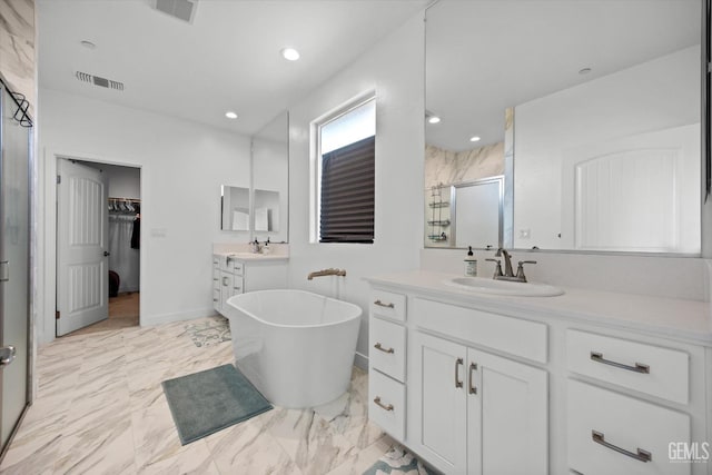 bathroom featuring vanity and independent shower and bath