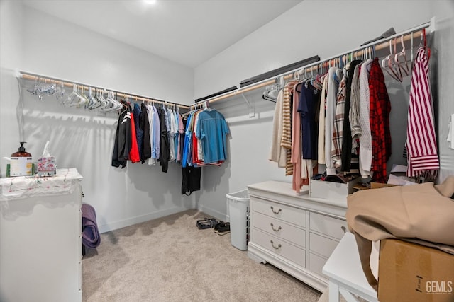 walk in closet featuring light carpet