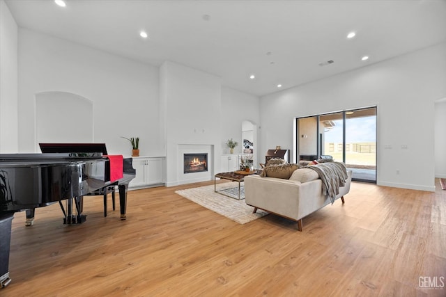 living room featuring a high ceiling and light hardwood / wood-style floors