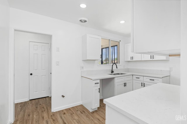 1920 Doolittle Ave, Bakersfield, CA 93304 - kitchen with a sink, light wood finished floors, white cabinetry, baseboards, and recessed lighting