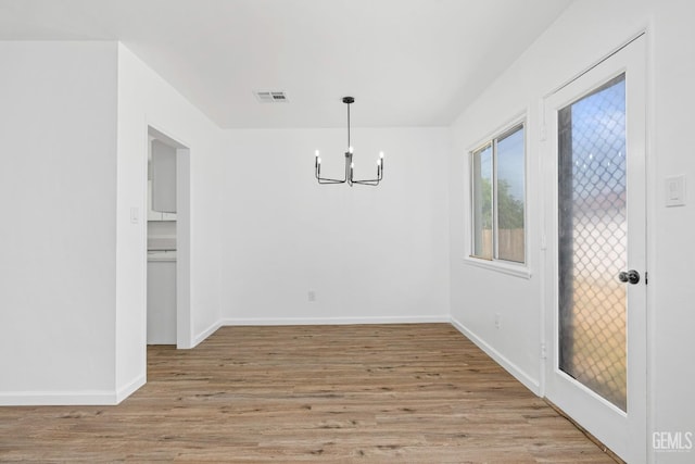 1920 Doolittle Ave, Bakersfield, CA 93304 - unfurnished dining area featuring a chandelier, light wood-type flooring, and baseboards