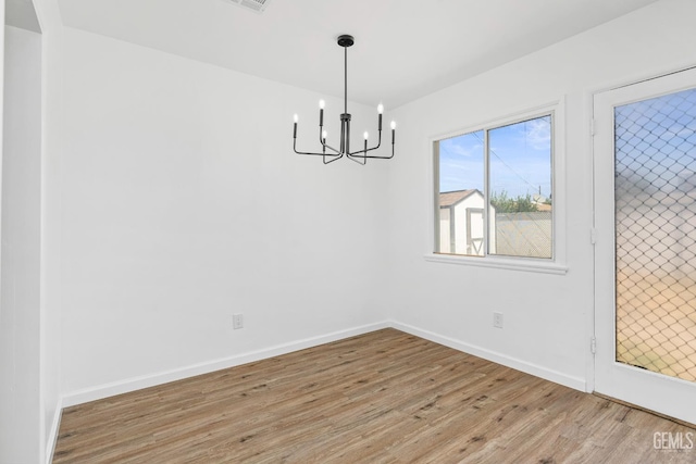 1920 Doolittle Ave, Bakersfield, CA 93304 - unfurnished dining area featuring wood finished floors, a chandelier, and baseboards