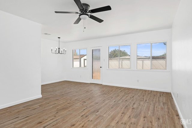 1920 Doolittle Ave, Bakersfield, CA 93304 - empty room with a chandelier, light wood-style flooring, baseboards, and a ceiling fan