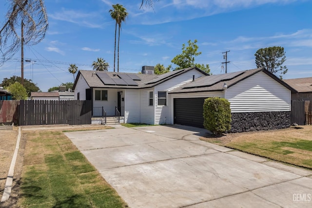 1920 Doolittle Ave, Bakersfield, CA 93304 - single story home featuring concrete driveway, roof mounted solar panels, a garage, and roof with shingles