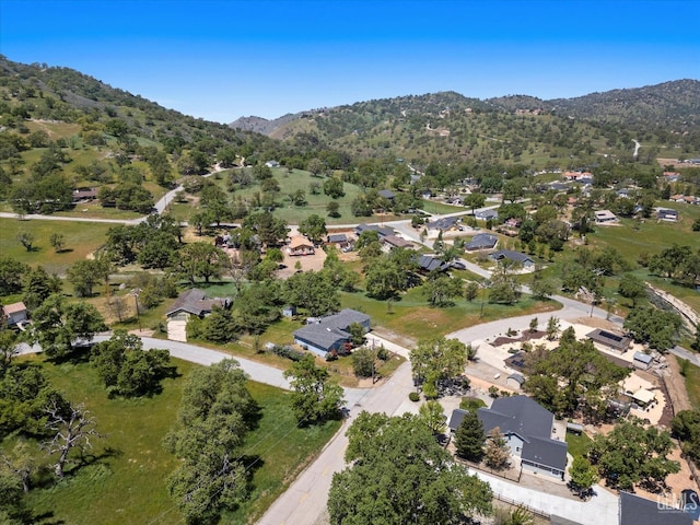 aerial view of property's location featuring a mountainous background and nearby suburban area