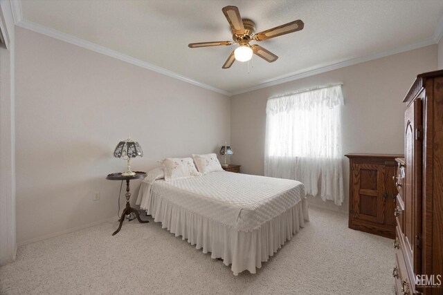 bedroom featuring light colored carpet, ornamental molding, ceiling fan, and baseboards