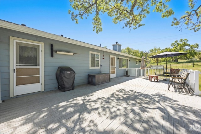 wooden deck featuring a grill
