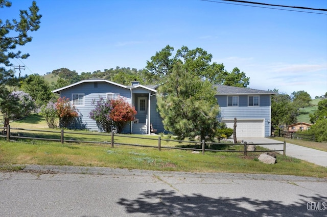 view of property hidden behind natural elements featuring concrete driveway and an attached garage