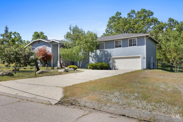 view of front facade featuring fence, driveway, and an attached garage