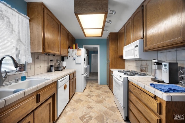 kitchen with white appliances, tile counters, and tasteful backsplash