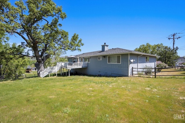 rear view of property featuring a chimney, stairs, and a deck