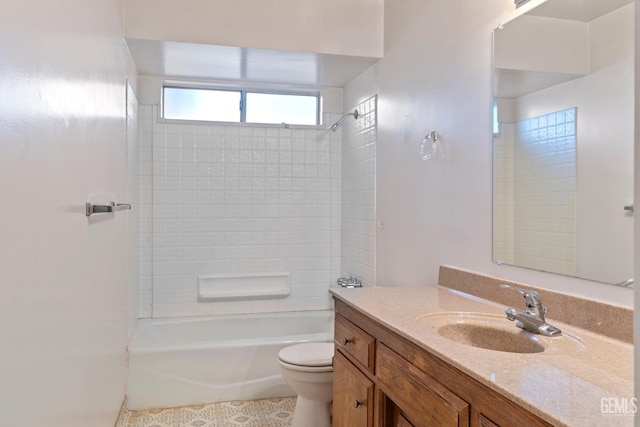 full bathroom with tiled shower / bath, vanity, and toilet