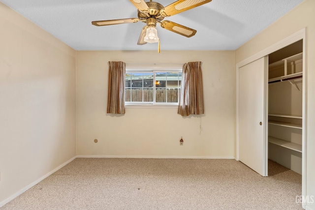 unfurnished bedroom featuring a closet, light carpet, ceiling fan, and a textured ceiling