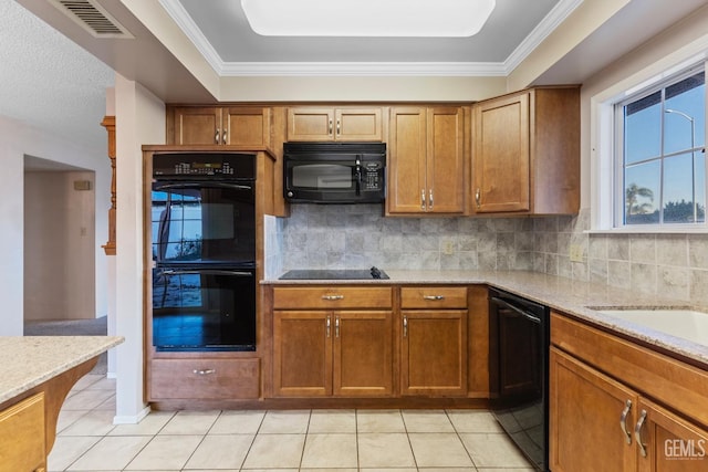 kitchen featuring light tile patterned floors, black appliances, and crown molding