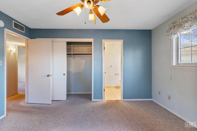 unfurnished bedroom with light colored carpet, ceiling fan, and a closet