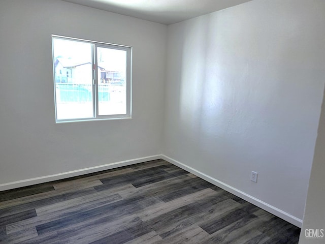 unfurnished room featuring dark wood-style floors and baseboards