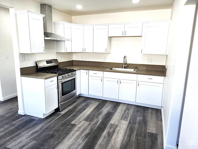 kitchen with white cabinetry, a sink, stainless steel gas range oven, and wall chimney exhaust hood