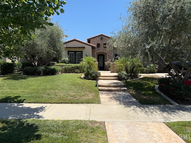 2410 Exton St, Bakersfield, CA 93311 - mediterranean / spanish house with french doors, a tile roof, a front yard, stone siding, and stucco siding