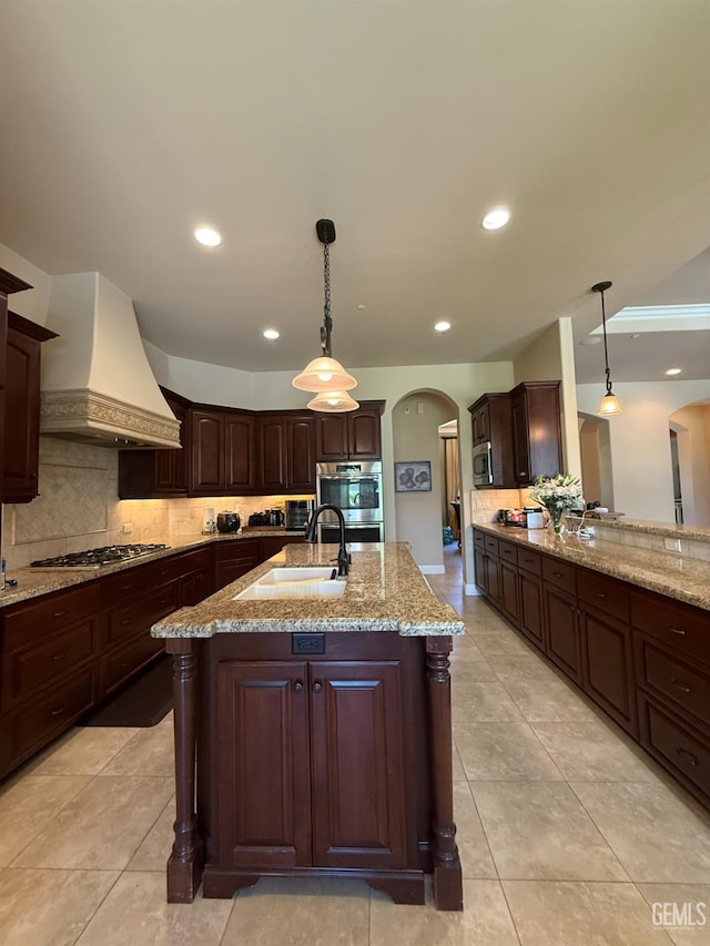 2410 Exton St, Bakersfield, CA 93311 - kitchen featuring arched walkways, custom range hood, decorative backsplash, stainless steel appliances, and recessed lighting