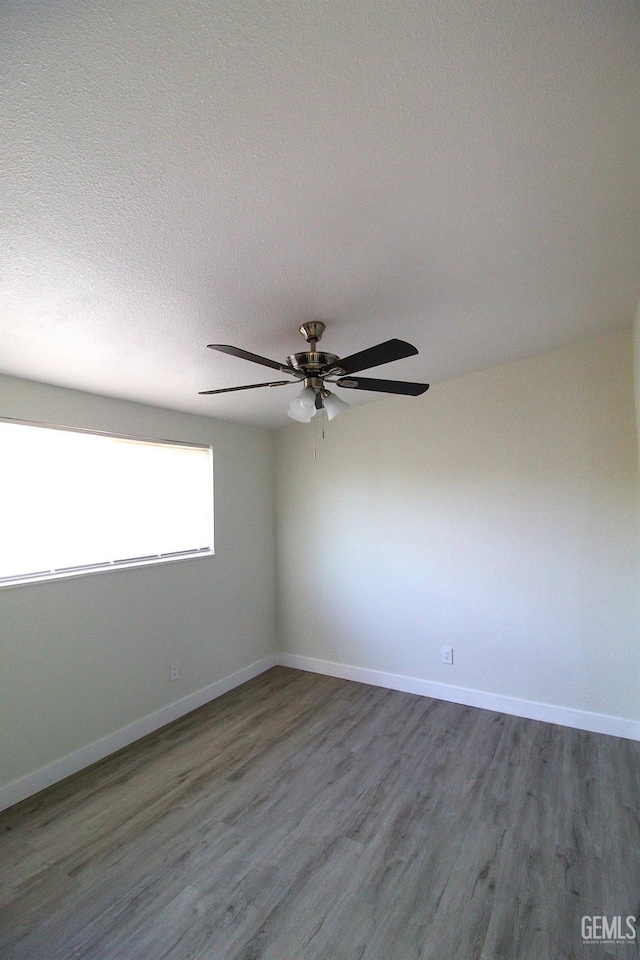 118 W 20th Ave, Delano, CA 93215 - empty room with wood finished floors, a ceiling fan, baseboards, and a textured ceiling