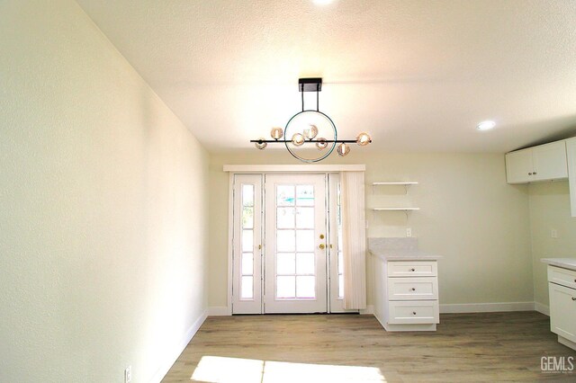 118 W 20th Ave, Delano, CA 93215 - entryway with light wood-style floors, a chandelier, and baseboards