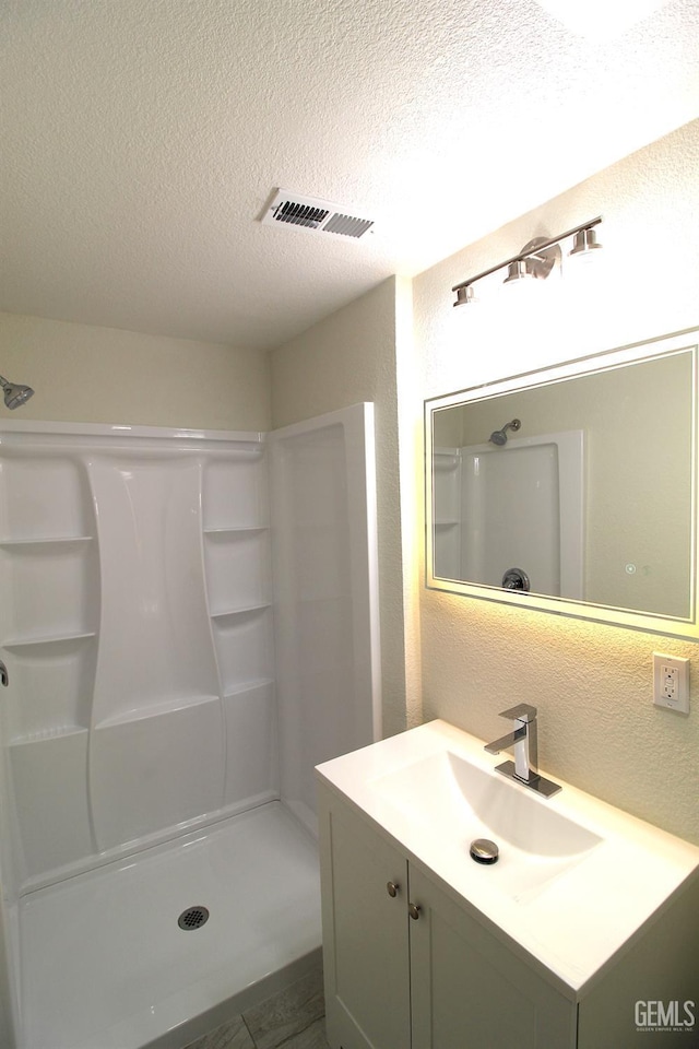 118 W 20th Ave, Delano, CA 93215 - full bath with a textured ceiling, walk in shower, a textured wall, and vanity
