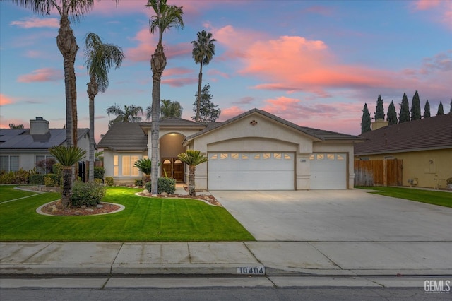 view of front of property featuring a garage and a lawn