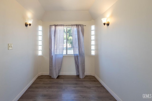 empty room featuring dark hardwood / wood-style floors and vaulted ceiling