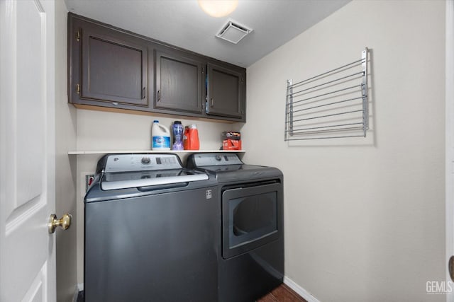 washroom featuring cabinets and washer and clothes dryer