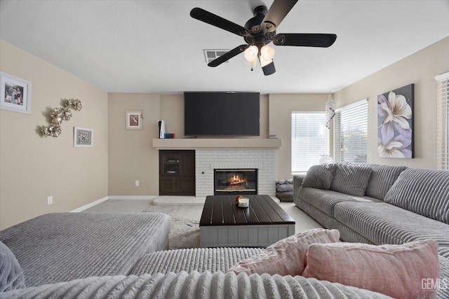 living room featuring ceiling fan, a fireplace, and light carpet