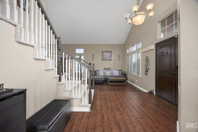 entryway featuring dark hardwood / wood-style flooring, high vaulted ceiling, and an inviting chandelier