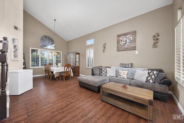 living room with dark hardwood / wood-style flooring and high vaulted ceiling