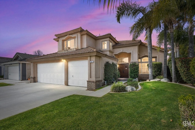 mediterranean / spanish house with a garage and a lawn