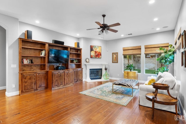 living room featuring hardwood / wood-style floors and ceiling fan