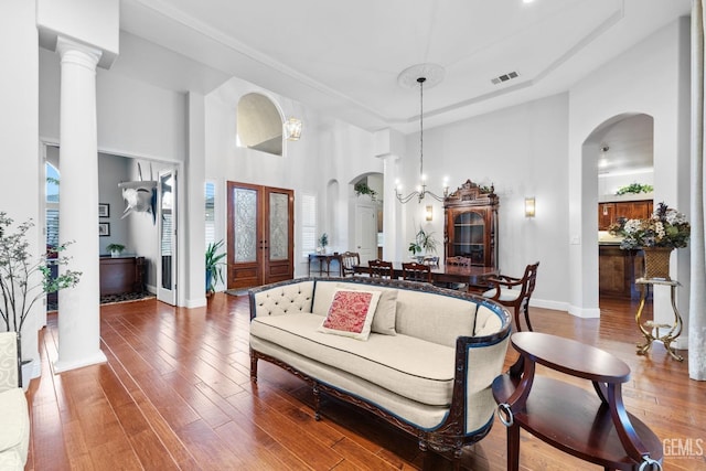 living room featuring hardwood / wood-style flooring, a healthy amount of sunlight, and a high ceiling