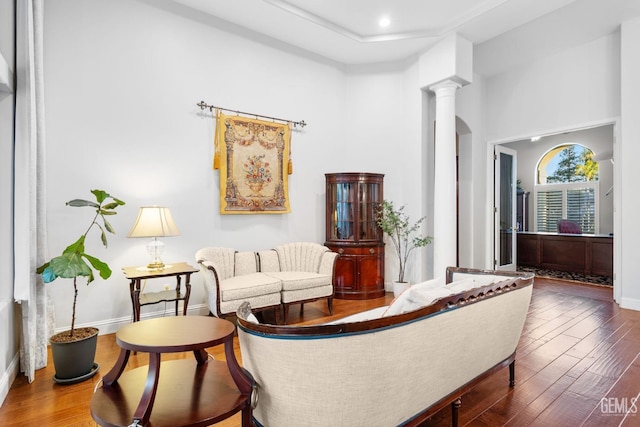 sitting room with wood-type flooring and ornate columns