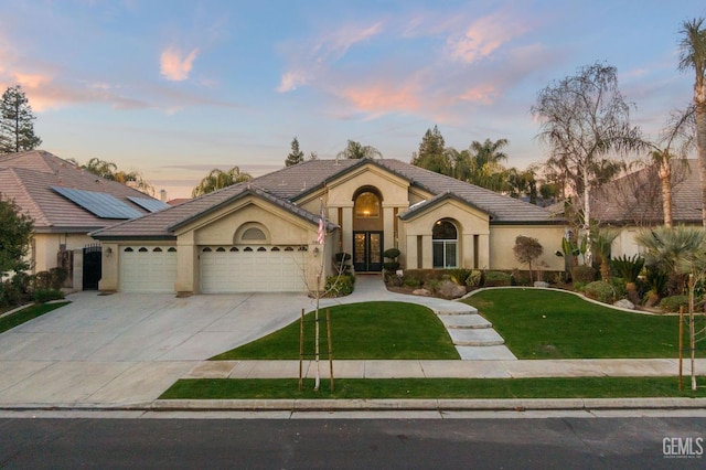 view of front of property with a garage and a lawn