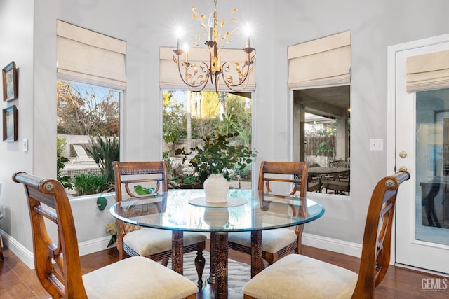 dining room with dark wood-type flooring and a chandelier