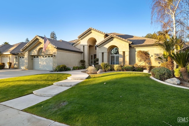 mediterranean / spanish house featuring a garage and a front lawn