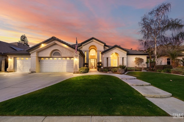 mediterranean / spanish house with a garage and a yard