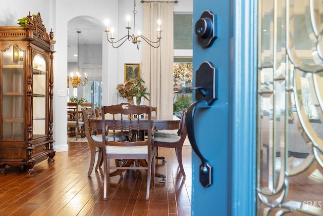 dining room featuring dark wood-type flooring, a wealth of natural light, and a notable chandelier