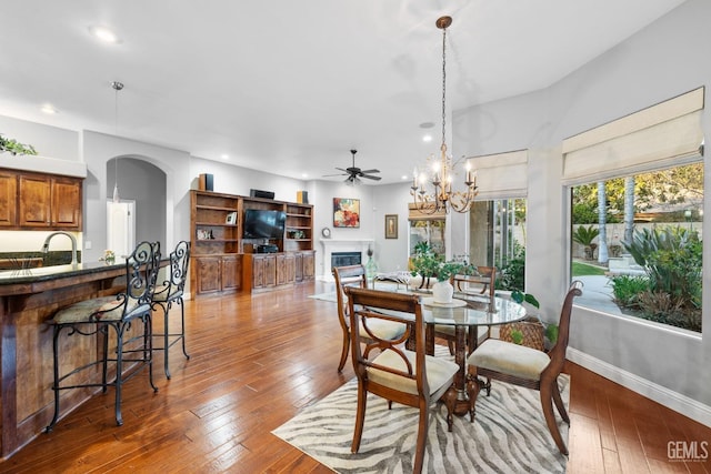 dining area featuring ceiling fan with notable chandelier and hardwood / wood-style floors