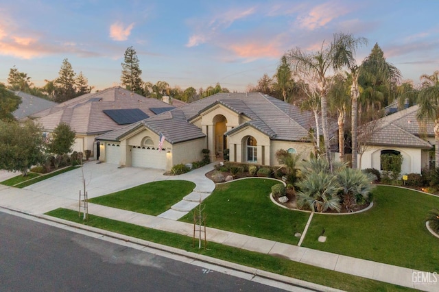 view of front of house featuring a garage and a lawn