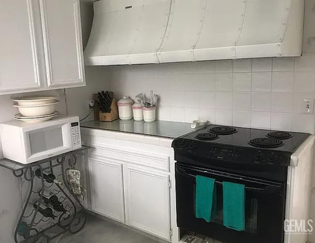 24551 Pueblo Ct, Tehachapi, CA 93561 - kitchen featuring electric range, white microwave, exhaust hood, decorative backsplash, and white cabinets