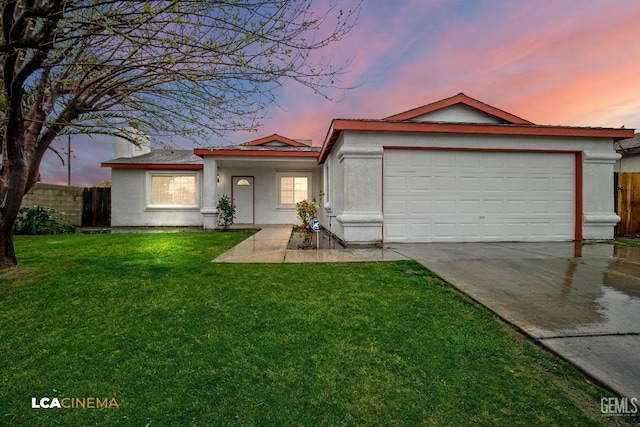 ranch-style home with concrete driveway, an attached garage, a lawn, and fence