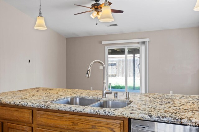 11602 Trabancos Dr, Bakersfield, CA 93311 - kitchen with stainless steel dishwasher, brown cabinetry, ceiling fan, light stone countertops, and pendant lighting