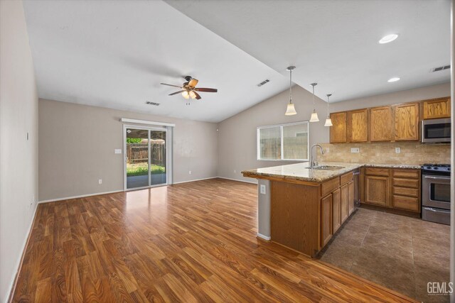 11602 Trabancos Dr, Bakersfield, CA 93311 - kitchen featuring appliances with stainless steel finishes, brown cabinetry, a peninsula, ceiling fan, and open floor plan